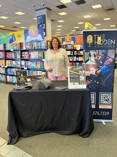 A woman standing next to a table with books on it.